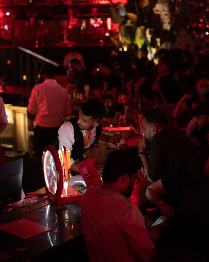 Barra de un venue con meseros atendiendo en plena noche